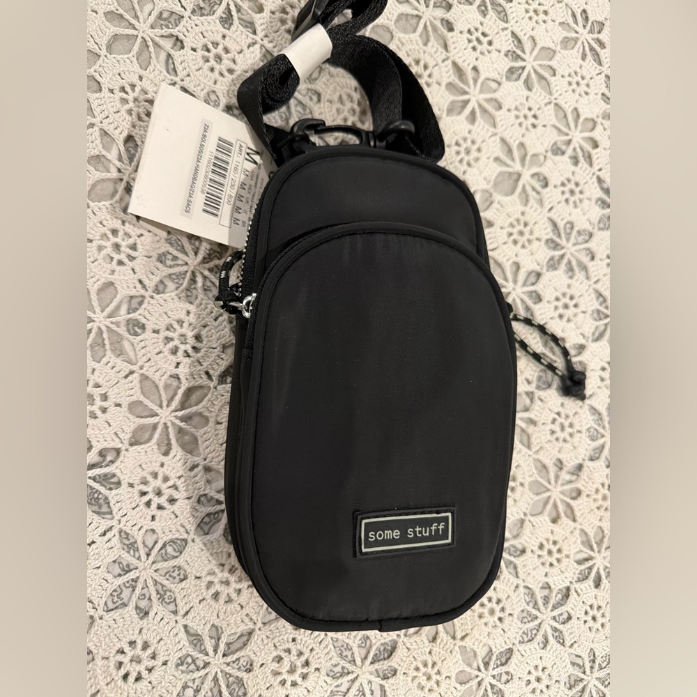 A black crossbody phone bag, similar in style to small sling bag